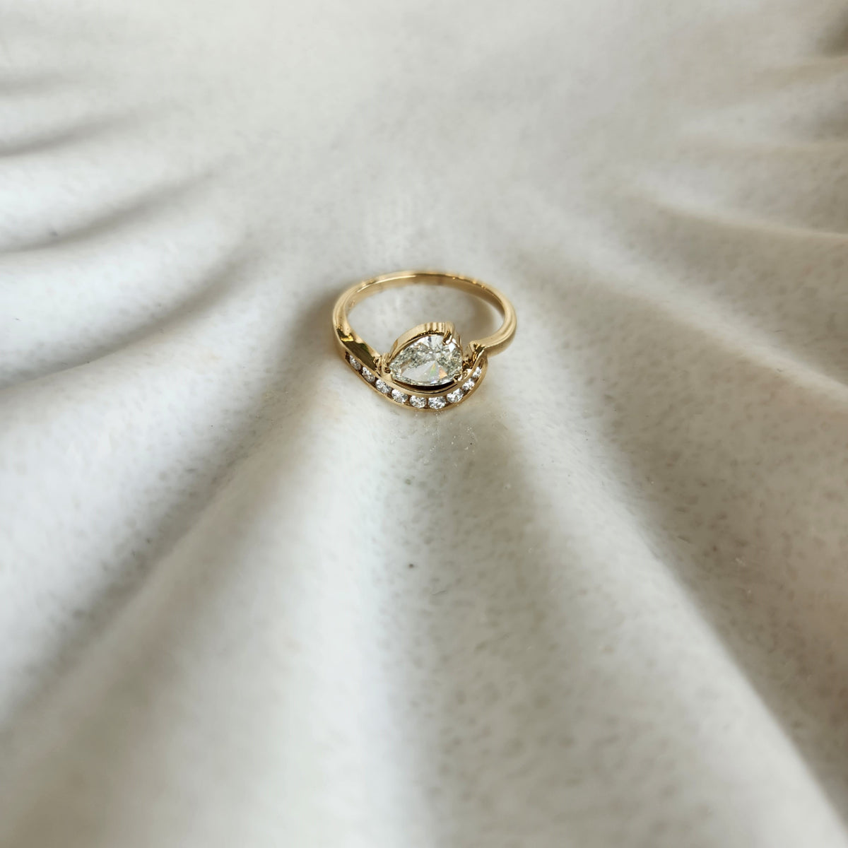 14 Karat Yellow Gold Pear Shaped Diamond "Wave" Design Ring With Channel Set Diamond Accents