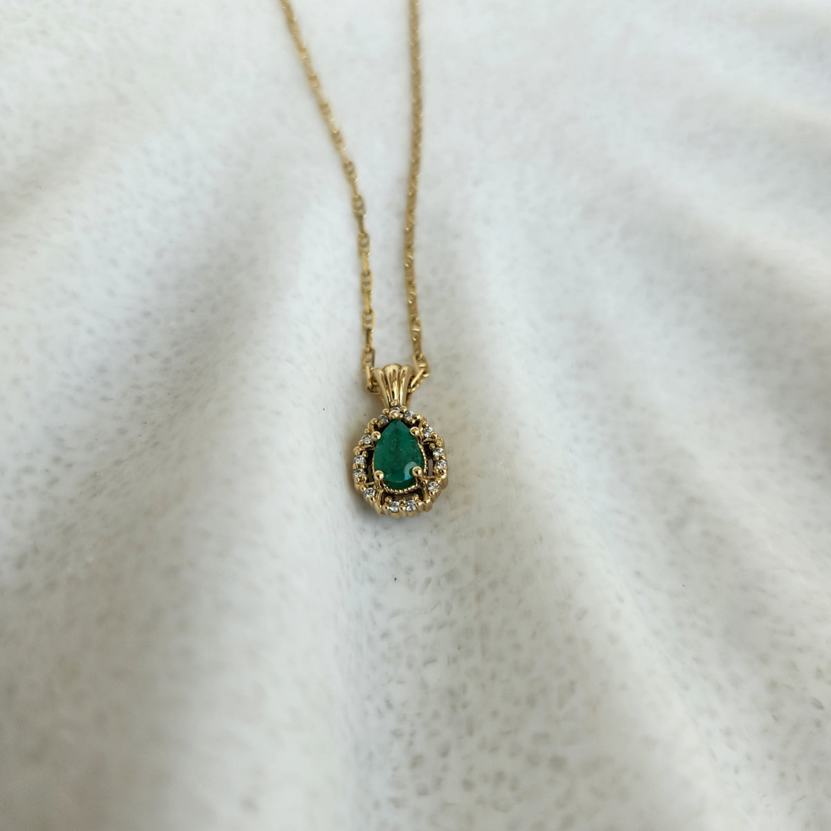 14 Karat Yellow Gold Pear Shaped Emerald Pendant With Diamond Halo
