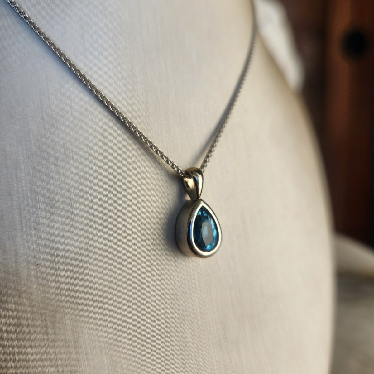 14 Karat White Gold Bezel Set Pear Blue Topaz Solitaire Pendant