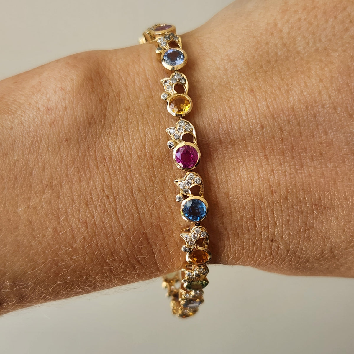 18 karat yellow gold multi-color sapphire bracelet with accent diamonds, 7"